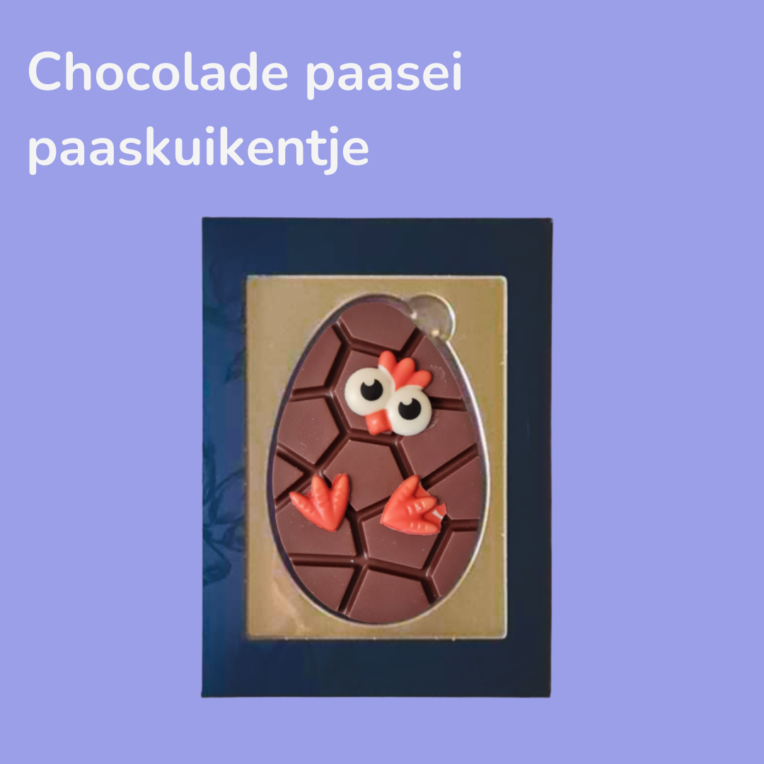 Chocolade paaskuiken in de vorm van een ei, met oogjes en pootjes van gekleurde chocolade, verpakt in een doosje tegen een paarse achtergrond.