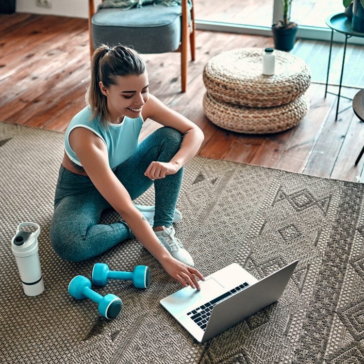 A,Sporty,Woman,In,Sportswear,Is,Sitting,On,The,Floor